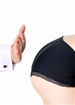 A young woman's bottom in black panties getting spanked by a man's hand